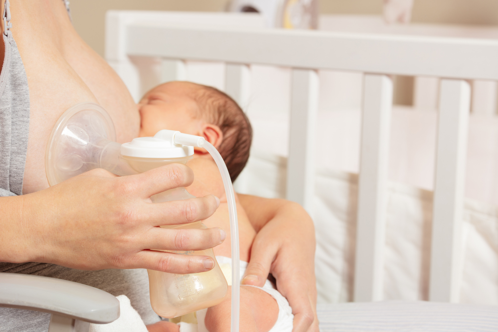Breast pump close up and mother breastfeed baby in nursery